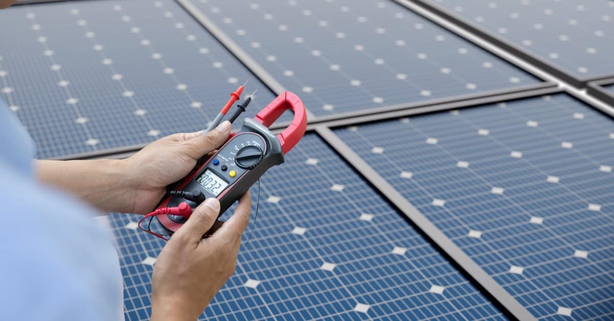 Technicus meet de spanning van zonnepanelen met een multimeter